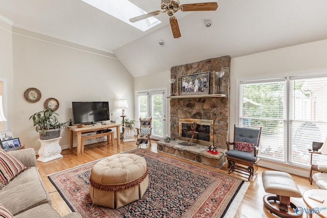 227 Key Turney Rd, Falkville, AL 35622 - living room featuring ceiling fan, a skylight, high vaulted ceiling, light hardwood / wood-style floors, and a stone fireplace