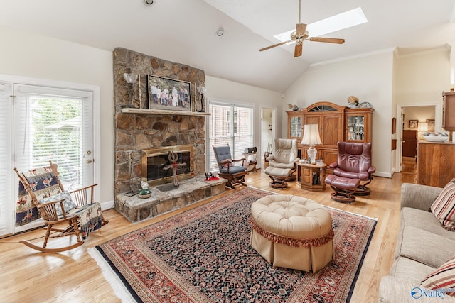 227 Key Turney Rd, Falkville, AL 35622 - living room featuring a healthy amount of sunlight, a fireplace, light hardwood / wood-style flooring, and lofted ceiling with skylight