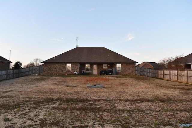 back of house with brick siding and a fenced backyard