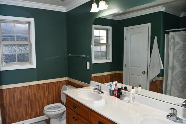full bath with toilet, crown molding, a sink, and a wainscoted wall