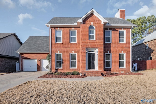 colonial house featuring a garage and a front lawn