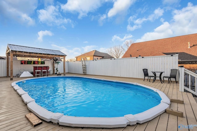 view of pool with a gazebo, an outdoor bar, and a deck