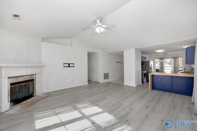107 Harvest Glen Ln, Harvest, AL 35749 - unfurnished living room featuring a ceiling fan, lofted ceiling, a fireplace, and visible vents