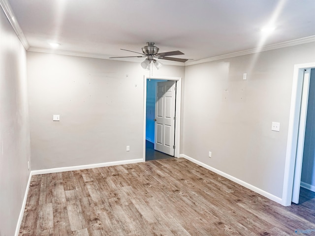 unfurnished room with a ceiling fan, crown molding, baseboards, and wood finished floors