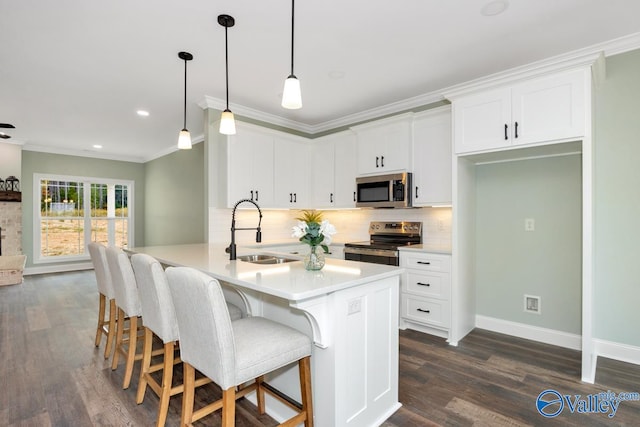 kitchen with sink, appliances with stainless steel finishes, white cabinets, and dark hardwood / wood-style flooring