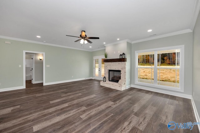 unfurnished living room with ceiling fan, ornamental molding, a brick fireplace, and dark hardwood / wood-style floors