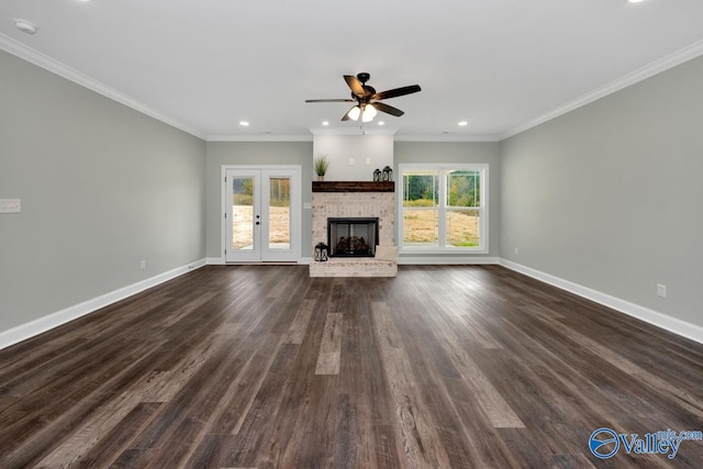 unfurnished living room with ornamental molding, dark wood-type flooring, ceiling fan, and plenty of natural light