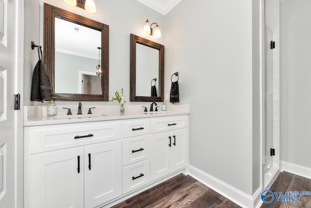 bathroom featuring vanity, ornamental molding, an enclosed shower, and hardwood / wood-style floors