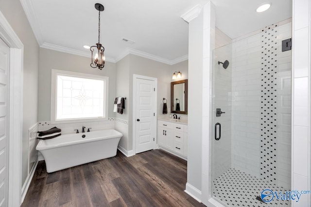 bathroom featuring plus walk in shower, vanity, crown molding, hardwood / wood-style flooring, and an inviting chandelier