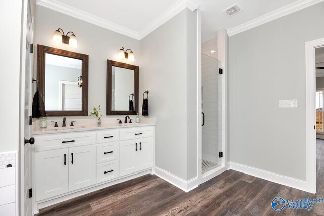 bathroom with vanity, ornamental molding, wood-type flooring, and an enclosed shower