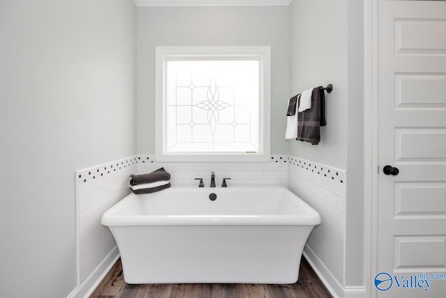 bathroom featuring a tub, wood-type flooring, and tile walls