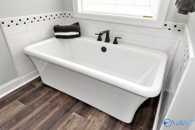 bathroom featuring hardwood / wood-style flooring, a healthy amount of sunlight, and a bathing tub