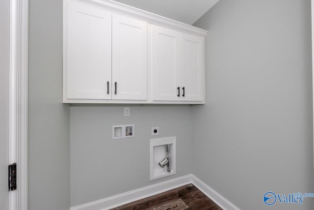 washroom with dark wood-type flooring, hookup for a washing machine, electric dryer hookup, and cabinets