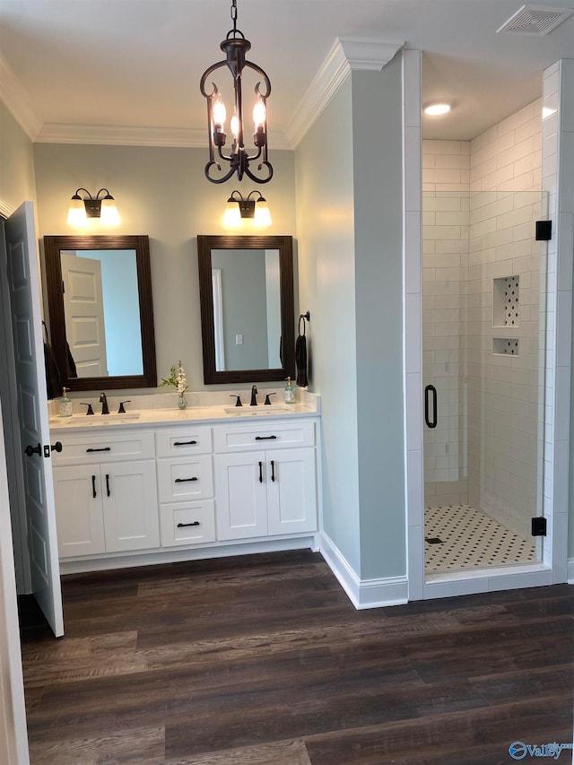 bathroom featuring wood-type flooring, walk in shower, vanity, crown molding, and a notable chandelier