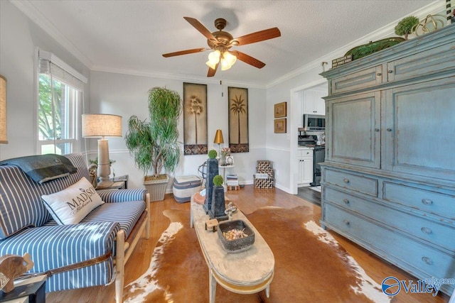 sitting room with a textured ceiling, dark hardwood / wood-style floors, ceiling fan, and ornamental molding