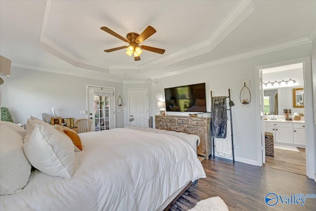 bedroom featuring connected bathroom, a tray ceiling, ceiling fan, and ornamental molding