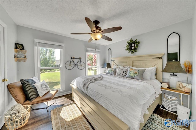 bedroom featuring a textured ceiling, ceiling fan, and dark hardwood / wood-style floors