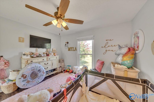 bedroom featuring ceiling fan, wood-type flooring, and a textured ceiling