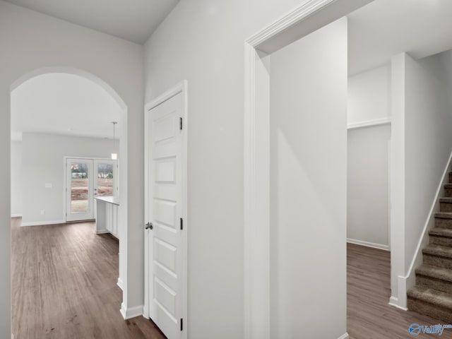 hallway with hardwood / wood-style floors and french doors