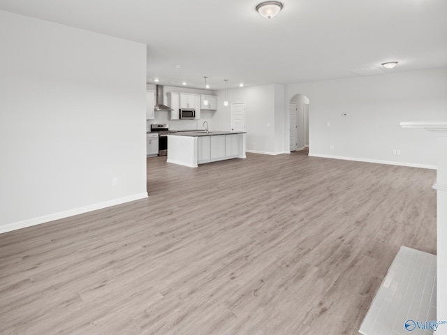 unfurnished living room featuring sink and light hardwood / wood-style flooring