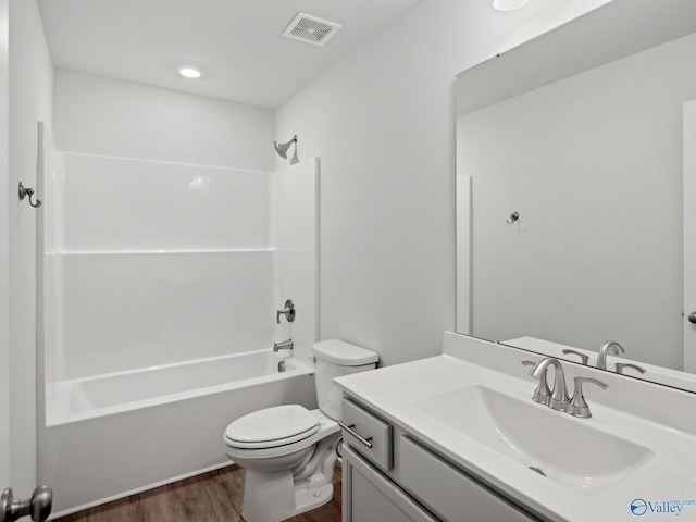 full bathroom with hardwood / wood-style flooring, vanity, toilet, and shower / washtub combination