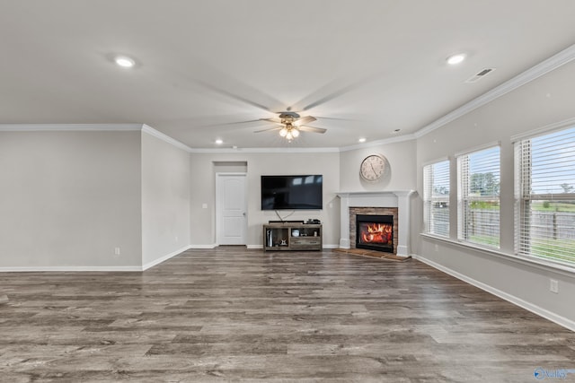 unfurnished living room featuring a fireplace, hardwood / wood-style flooring, ceiling fan, and crown molding