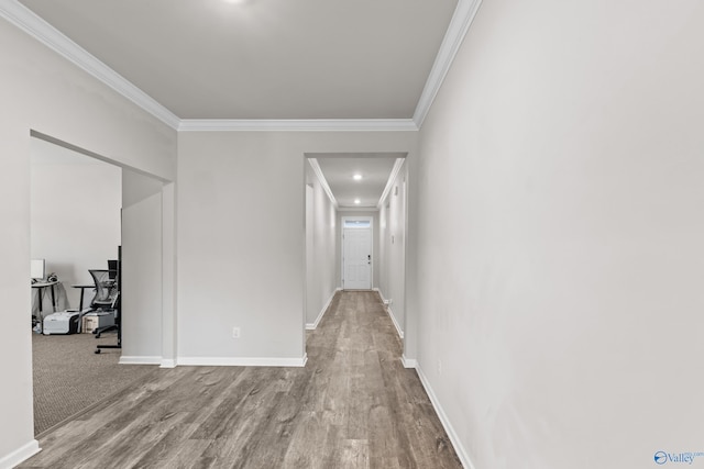 hallway with ornamental molding and light hardwood / wood-style flooring