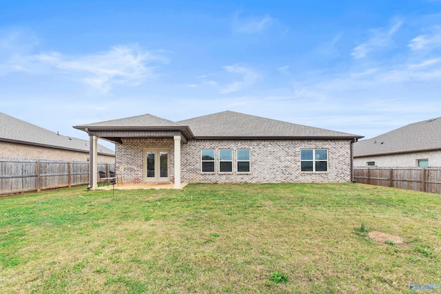 back of property with a yard and a patio