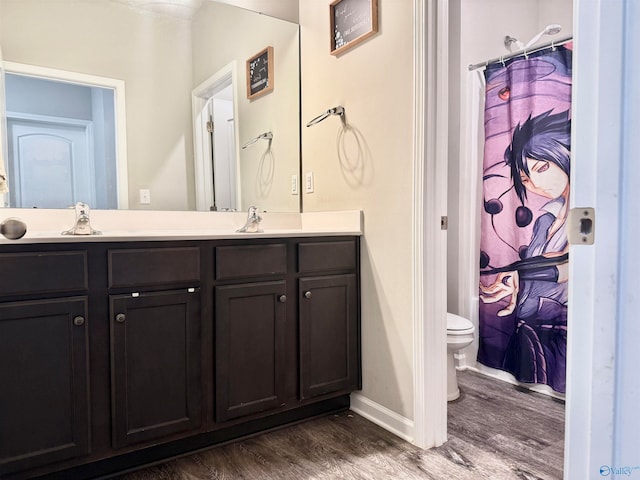 bathroom featuring wood-type flooring, vanity, toilet, and walk in shower