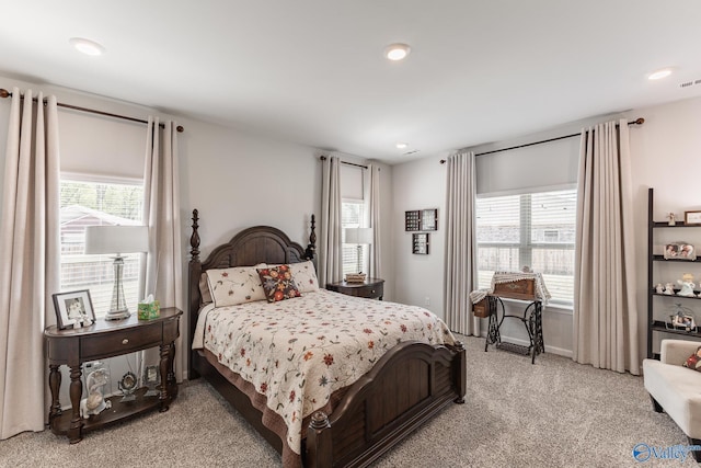 bedroom with light carpet, visible vents, recessed lighting, and multiple windows