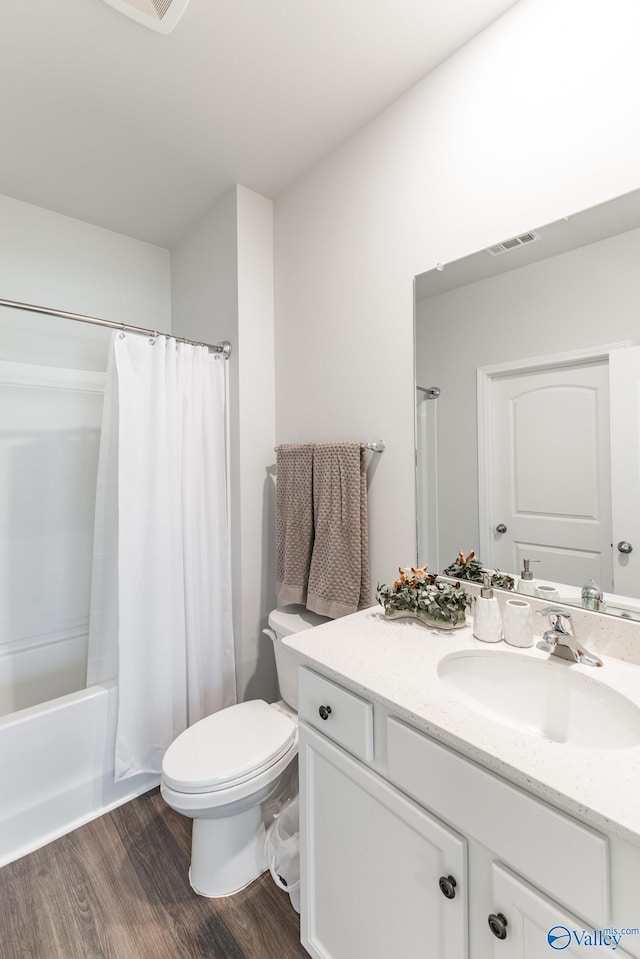 full bathroom with wood finished floors, visible vents, toilet, vanity, and shower / bath combo with shower curtain