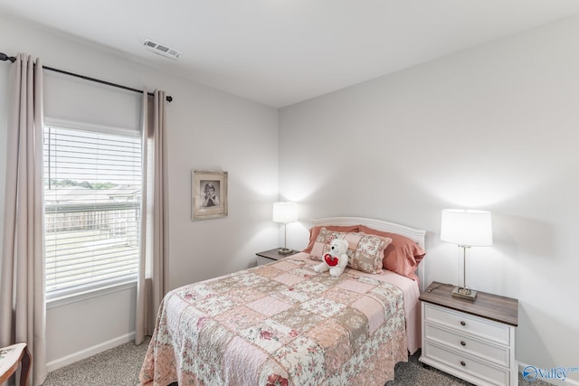 bedroom featuring baseboards, visible vents, carpet, and multiple windows