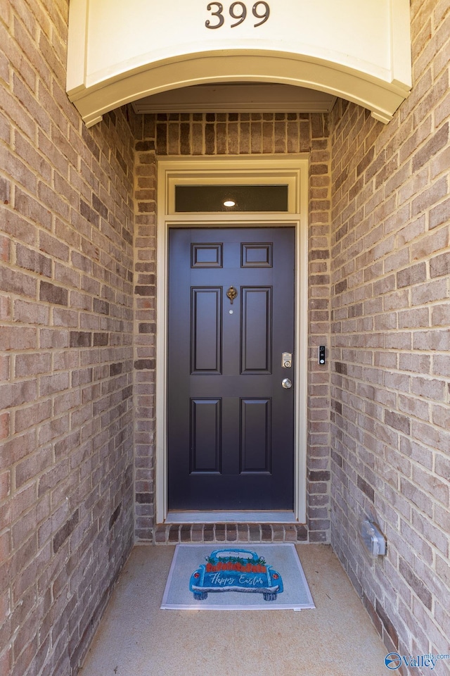 entrance to property featuring brick siding