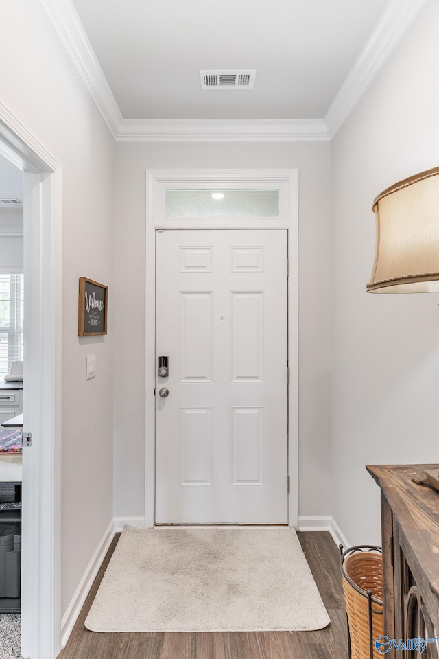 foyer entrance with baseboards, wood finished floors, visible vents, and ornamental molding
