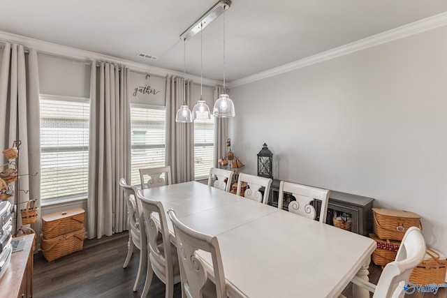 dining room featuring dark wood finished floors, plenty of natural light, visible vents, and ornamental molding