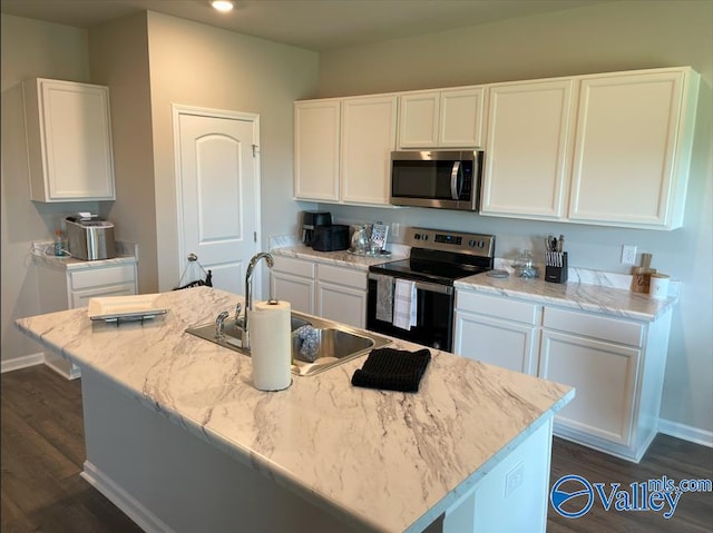 kitchen with a kitchen island with sink, appliances with stainless steel finishes, and white cabinets