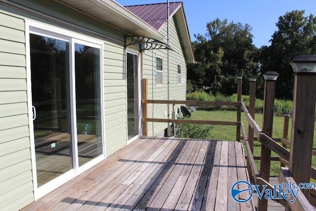 wooden terrace with a lawn