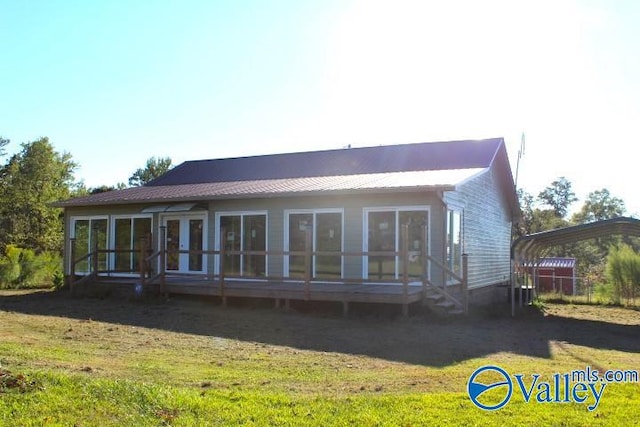 back of house featuring a sunroom and a lawn