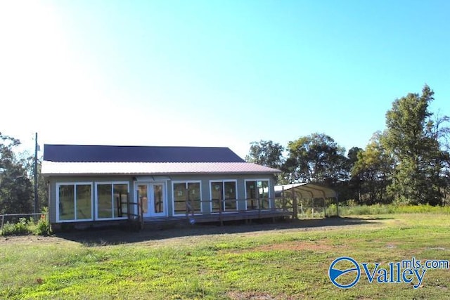 rear view of property with a yard and a carport