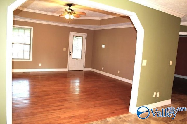 interior space featuring ceiling fan, ornamental molding, a tray ceiling, and hardwood / wood-style floors