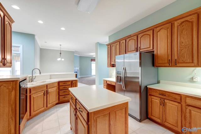 kitchen featuring a kitchen island, hanging light fixtures, light countertops, stainless steel refrigerator with ice dispenser, and a sink