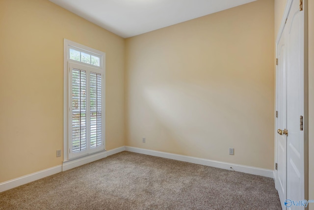 unfurnished room featuring baseboards and light colored carpet