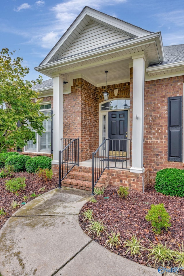 view of exterior entry featuring brick siding