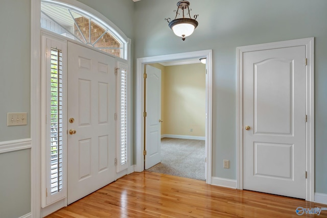 entryway with baseboards and light wood finished floors