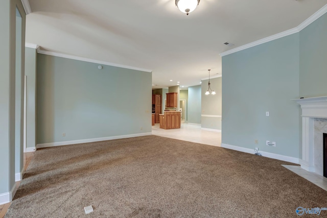 unfurnished living room with baseboards, visible vents, light colored carpet, a premium fireplace, and ornamental molding