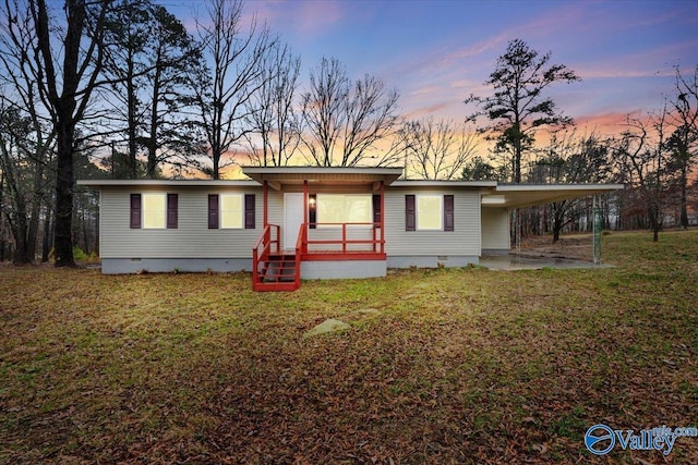 view of front facade featuring a carport and a lawn