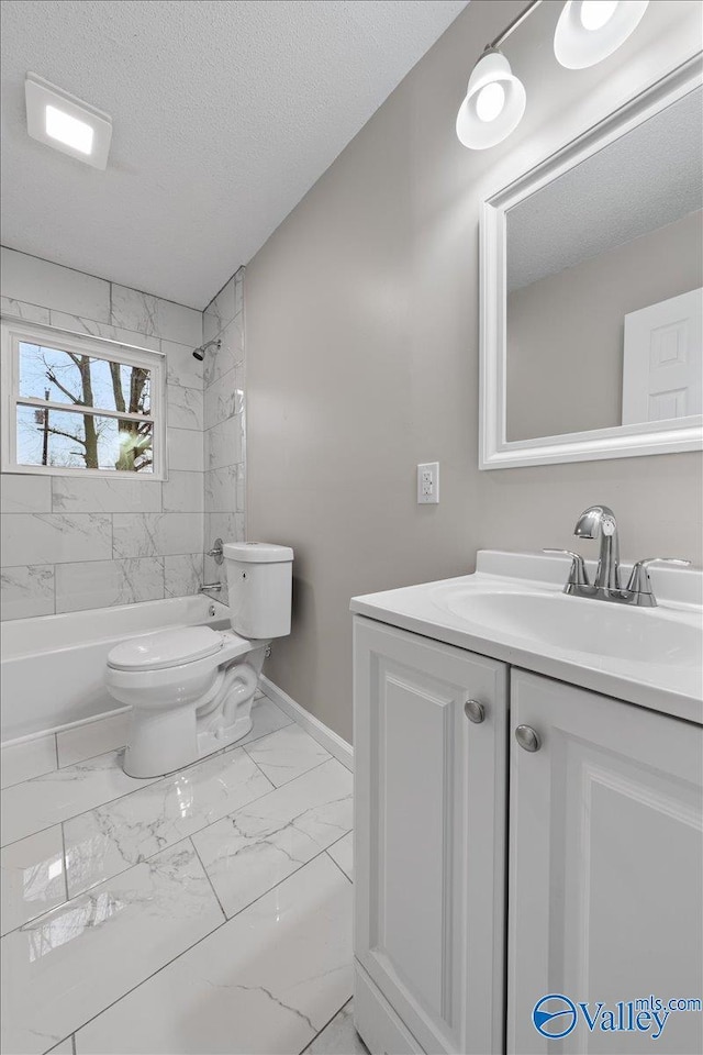 full bathroom with vanity, toilet, tiled shower / bath combo, and a textured ceiling