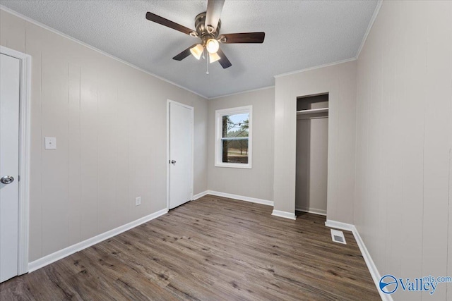 unfurnished bedroom with crown molding, hardwood / wood-style flooring, a closet, and a textured ceiling