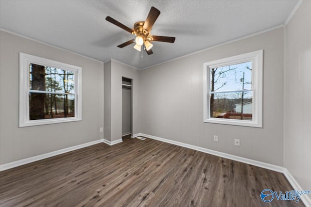 unfurnished bedroom with dark wood-type flooring, ornamental molding, and a textured ceiling