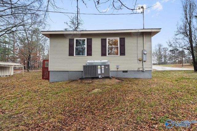 rear view of property featuring cooling unit and a yard